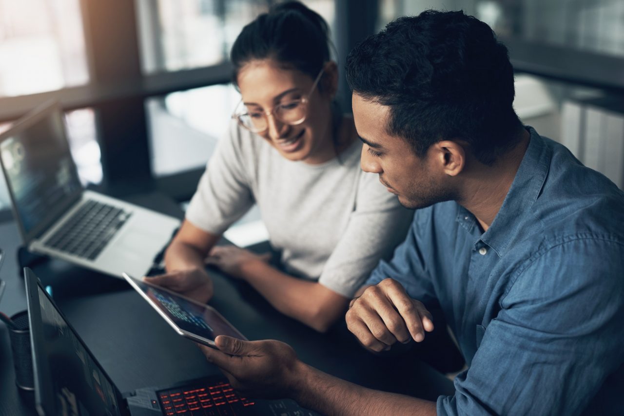 Shot of two young workers using a digital tablet in a modern office